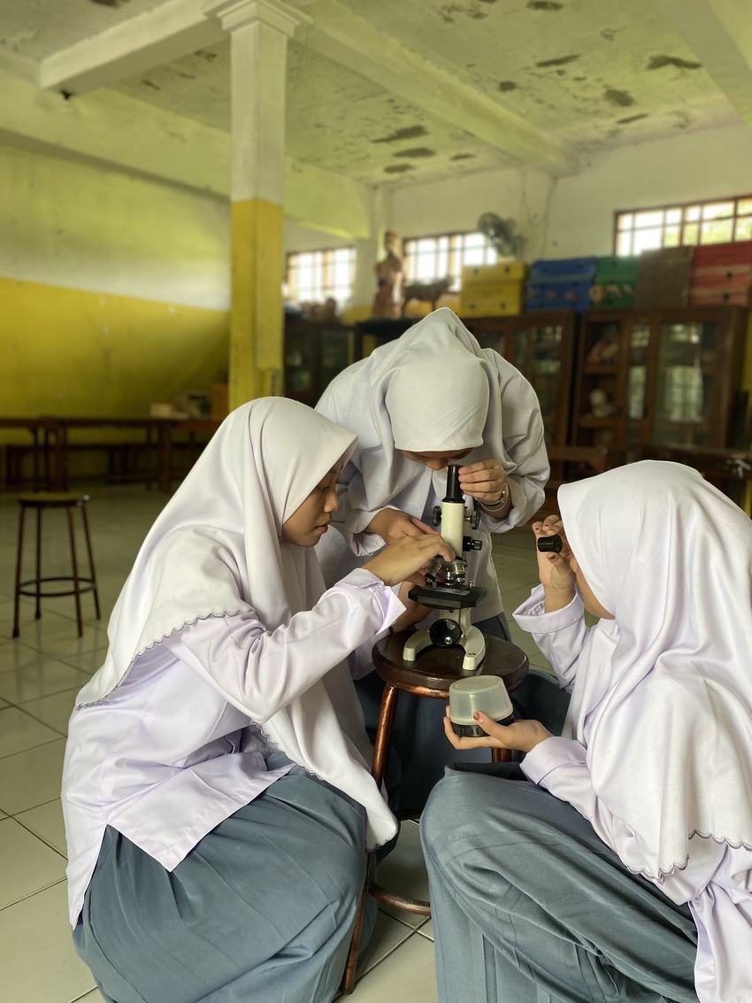 Siswa MA Nurul Qur'an melakukan praktikum menggunakan mikroskop
